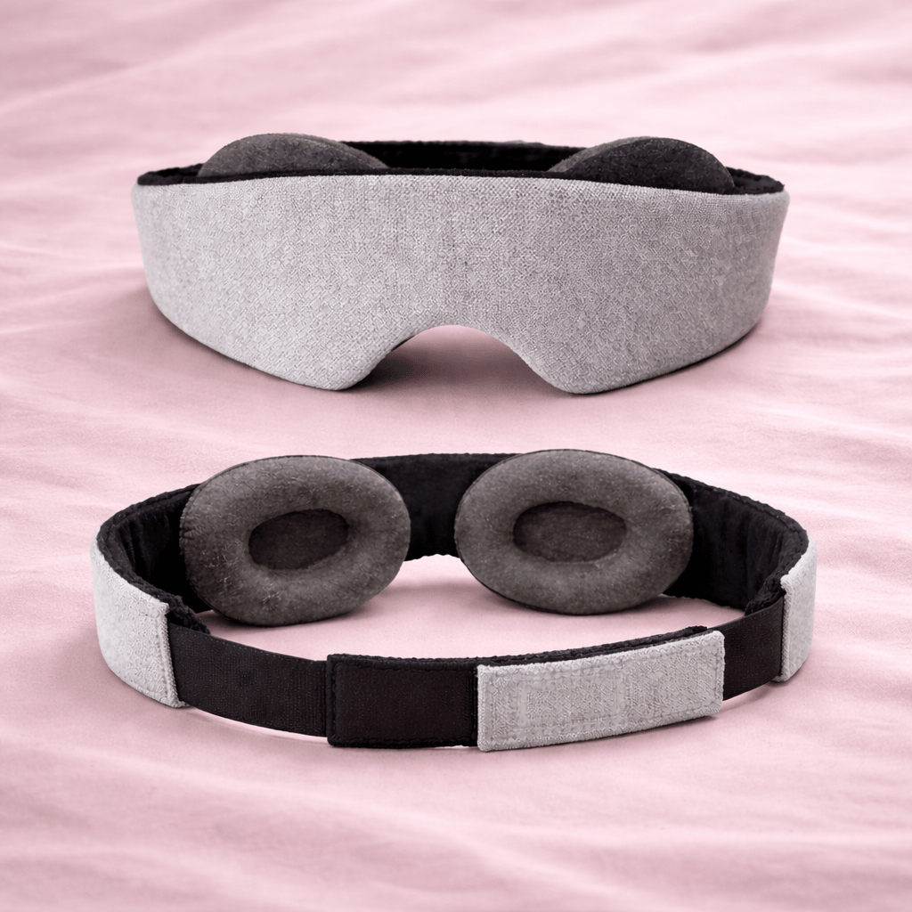 Masque de nuit 3D DreamLash gris sur tissu rose poudré, vue avec détail du design creux anti-frottement